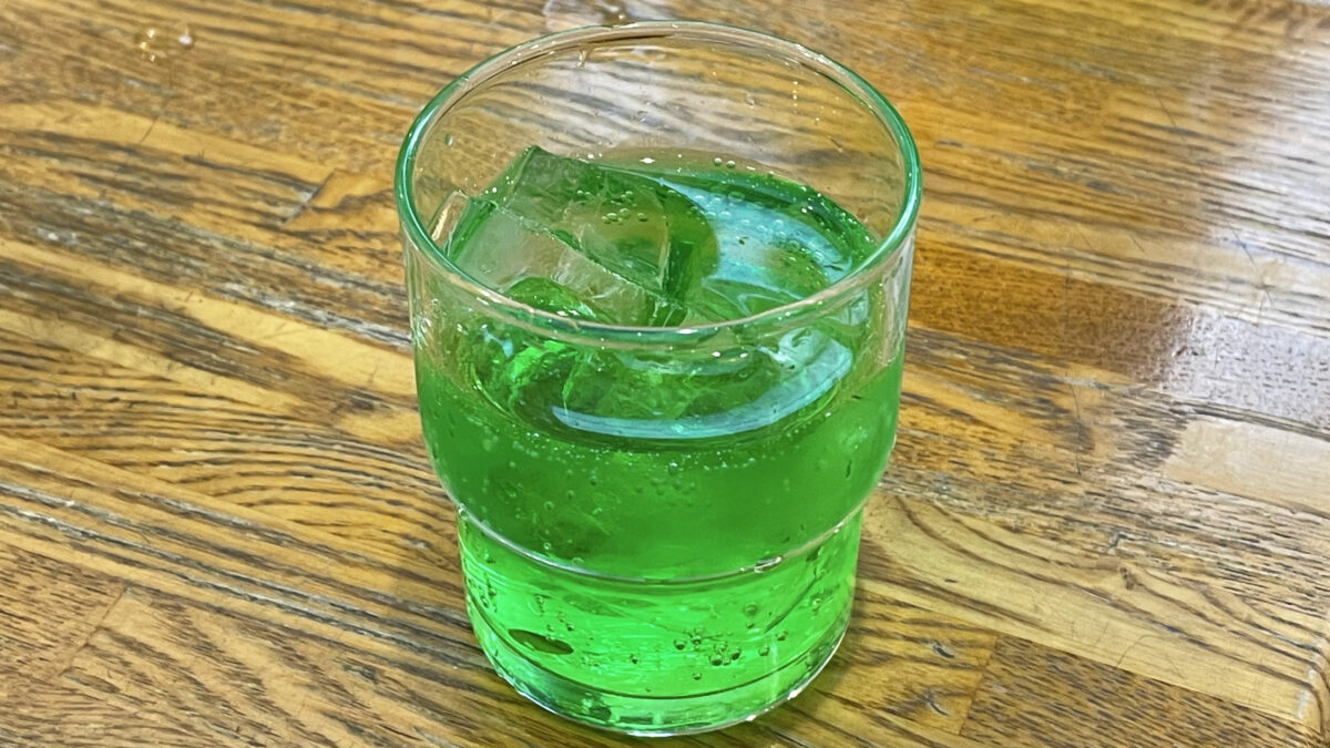 ふじもりのテーブルに置かれた鮮やかな緑色のメロンソーダ
